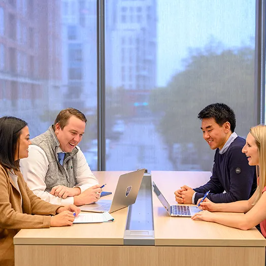 students working together at a table at johns Hopkins Carey Business school