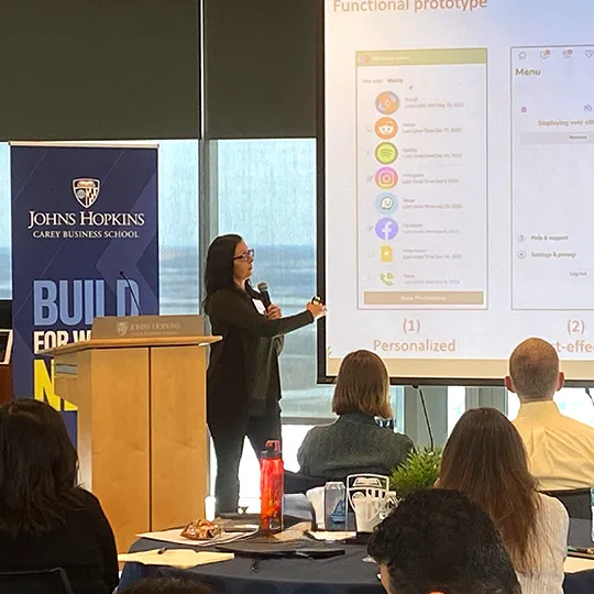 instructor at the front of class pointing to the screen