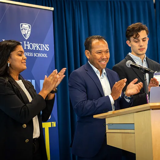three people at a podium at a conference