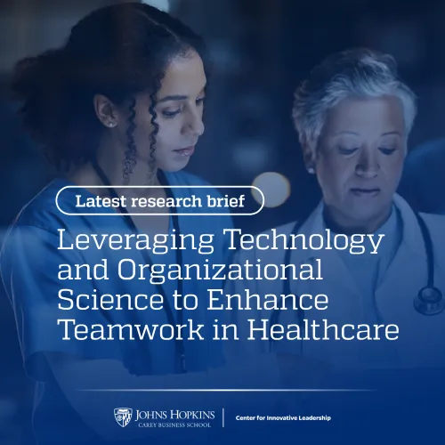 Two women, one in a white coat with a stethoscope around her neck and one with a lanyard around her neck, look at a glowing screen. The words "leveraging technology and organizational science to enhance teamwork in healthcare" appear in overlay.