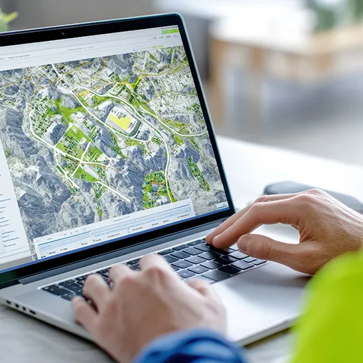 Seydina laptop with someone typing with an aerial view on the screen.