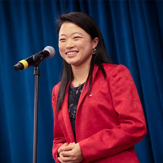 Erika Ido at a microphone on stage