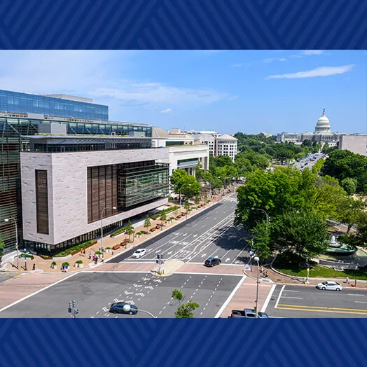 Aerial view of Johns Hopkins Carey Business School in Washington, D.C., with the U.S. Capitol in the distance