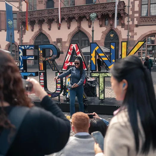 big 3d letters FRANK TRUTH behind a gathering or people and a speaker in the center